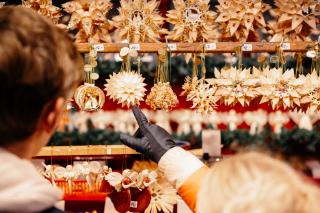 Gäste auf dem Christkindlmarkt vor den Strohsternen